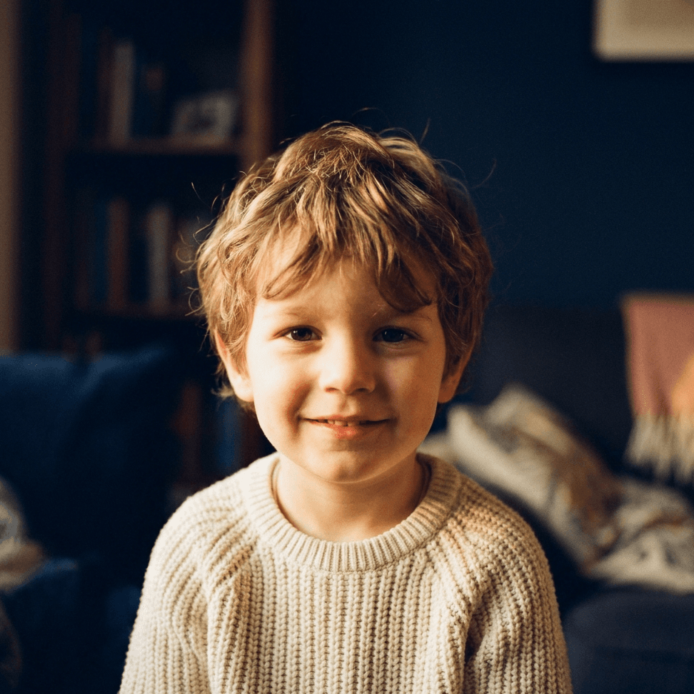 A warm photo portrait of a smiling young child in lamplight